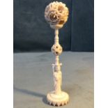 A carved ivory puzzle ball on stand, the pierced dragon sphere with interior balls supported on a