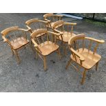 A set of six beech captains chairs with spindle backs and rounded platform arms above solid seats,