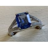 An 18ct white gold sapphire and diamond ring, the rectangular claw set unheated sapphire weighing