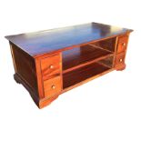 A rectangular mahogany coffee table, with open shelves and small drawers to both sides, having