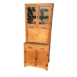 A 1930s Maidsaver Lusty kitchen cabinet, the top with leaded glass sunburst doors above a panelled