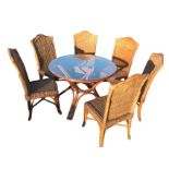 A cane dining room suite with circular glass top table on waisted legs, and six chairs with