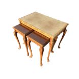 A walnut nest of tables with plate glass to tops having chisel carved moulded edges, raised on