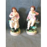 A pair of Victorian Staffordshire girl & boy figurines each holding birds in their hands,