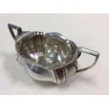 A hallmarked silver sucrié of oval scalloped form with ribbed handles - rubbed marks, 8.3oz. (7.