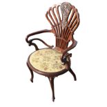 An Edwardian mahogany saloon chair with pierced scrolled back framing a foliate scroll carved panel,