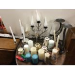 A collection of contemporary candelabra, candlesticks, stands, candles, etc., - some ecclesiastical.