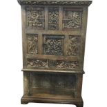 An eighteenth century oak vestal cupboard with pierced fruit & leaf carved cornice above a