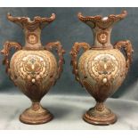 A pair of egg shaped European stoneware vases with oval scrolled rims, raised on circular moulded