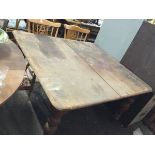 A Victorian dining table with pine top on mahogany turned legs with casters, having telescopic