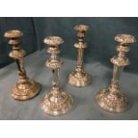 A set of four silver plated candlesticks of tapering column form, embossed with foliate scrolled