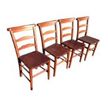 A set of four stained barback chairs with shaped back rails and solid seats, raised on turned legs &