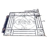 A rectangular wrought iron garden gate having central oval panel with scrolled decoration framed