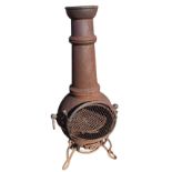 A cast iron garden chimera with tubular tapering chimney above a bulbous burning chamber mounted