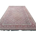 A large eastern kelim woven with central floral field framed by frieze of onion shaped star