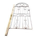 An arched 6ft wrought iron garden gate or door, with scrolled decoration and tubular spindles to