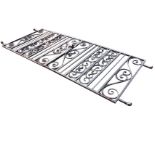 A pair of heavy wrought iron driveway gates with vertical scrolled panels to rectangular frames,