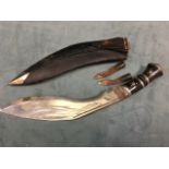 An eastern kukri knife with two subsidiary knives to leather sheath, the plated shaped blade
