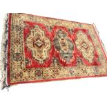 A chenille thick pile rug woven with three large hooked aztec style medallions on red field,
