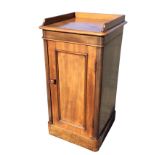 A Victorian mahogany pot cupboard with shaped gallery to moulded rounded top, having panelled door