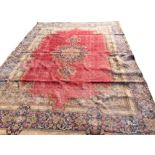 An Axminster style carpet having central circular floral medallion with pendants on red field,