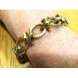 An 18ct gold bracelet with twelve oval hollow ribbed links joined by cross-over pinched rings -