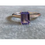 A tanzanite and sterling silver ring, the claw set rectangular stone of approx. 1 carat, raised in a