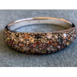A multi-sapphire cluster ring, the pave set mound with over 50 stones in pinks, yellow, orange,