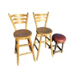 A pair of bar-back high chairs, the curved rails above circular seats, on turned legs and