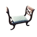 A regency style mahogany window seat with bow carved panels to chair-back ends in ribbed frames, the