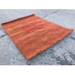 A contemporary shag-pile Turkish terracotta coloured rug. (64in x 90.5in)