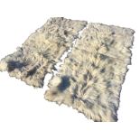 A pair of rectangular goatskin rugs with patched pelts. (64in x 29in) (2)
