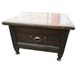 An antique oak box stool with rectangular top above a panelled box, the front with pierced carving