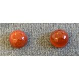 A pair of red jade gemstones, the round cut dyed loose stones of approx. 1.2 carats - boxed.