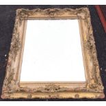 An antique mirror, the glass plate in a scroll carved pierced gilt & gesso frame. (40in x 35in)