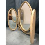 A painted dressing table mirror with three oval plates in floral embossed frames, the central mirror