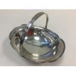 A hallmarked silver fruit basket with swing handle, the bowl of scalloped form, raised on oval