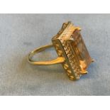 A citrine and zircon ring, the large rectangular claw set baguette cut citrine of approx. 8.8