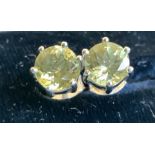 A pair of yellow apatite stud earrings, the princess cut stones in sterling silver claw settings,