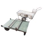 A rectangular trolley cart with mesh basket on stand; and another flatbed four-wheel cart with