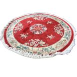 A circular Chinese thick pile wool rug woven with vases of flowers on red field, the frieze of