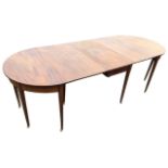A nineteenth century mahogany dining table in three sections, the central part with drop leaves
