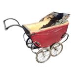 A vintage pram with tin body having padded lining and concertina hood, supported on a sprung frame