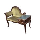 A chaise style telephone table with scroll carved upholstered back above a cushion seat flanked by