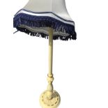 A painted standard lamp with fluted leaf carved column on circular base with bun feet, mounted