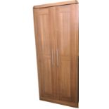 A modern faux walnut wardrobe with panelled doors enclosing hanging space, rail and hat shelf. (33.