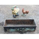 A rectangular cast iron trough moulded with swags and urns to sides; a painted cast iron Mr Punch