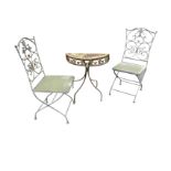 A circular wrought iron garden table and pair of folding chairs, having scrolled decoration to backs