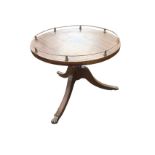 A circular reproduction mahogany coffee table, the top with brass gallery rail supported on a turned