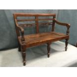 A rectangular hardwood childs bench having bar back and pierced rails carved with flowerheads,